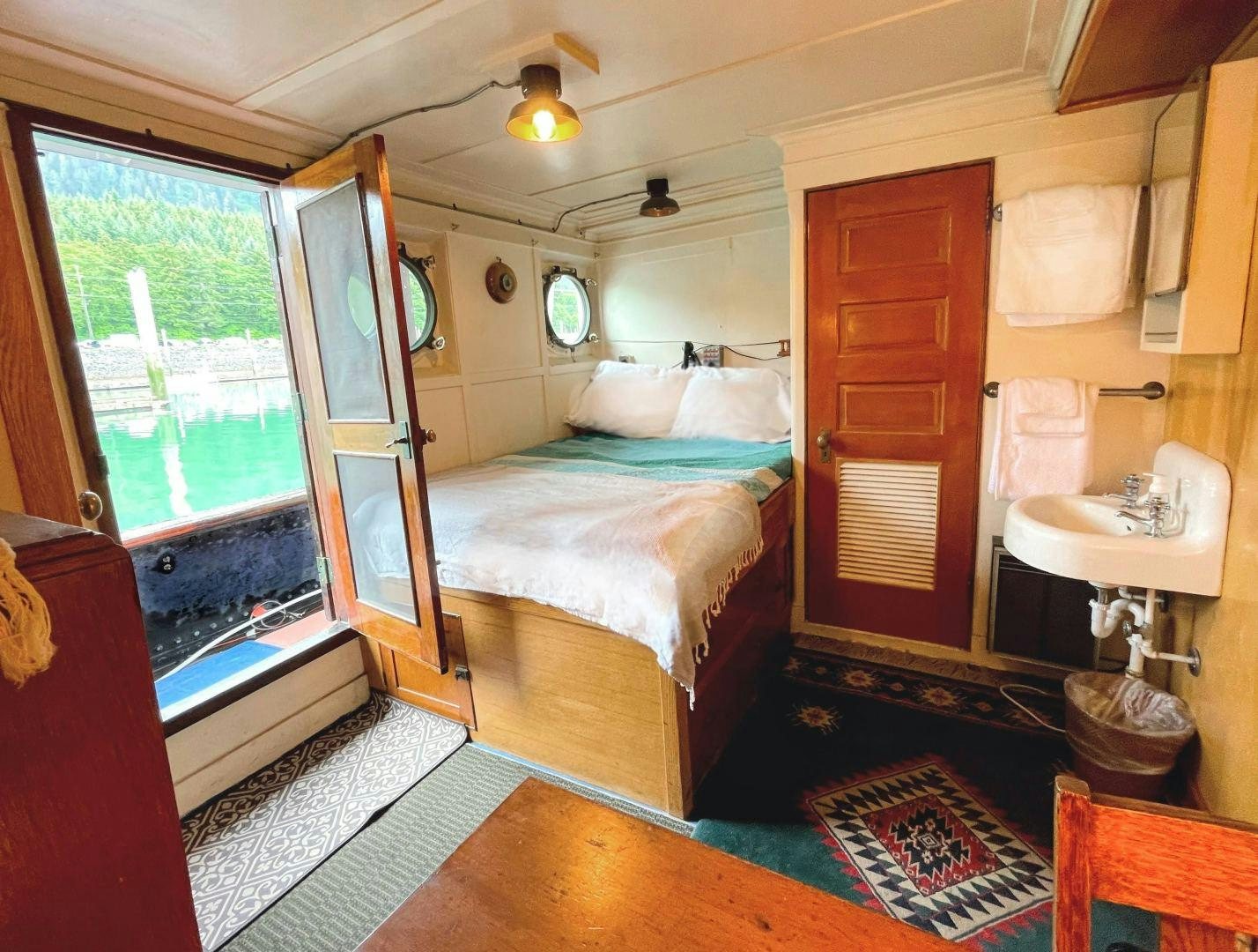 a bedroom with a bed and sink aboard SACAJAWEA Yacht for Sale