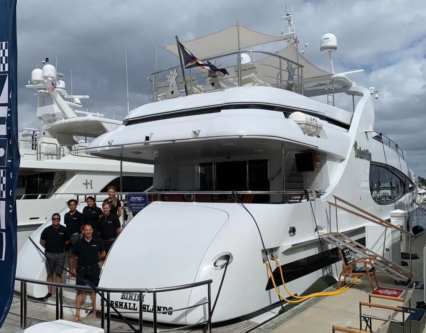 a group of people standing next to a large white boat aboard ARTHUR’S WAY Yacht for Sale
