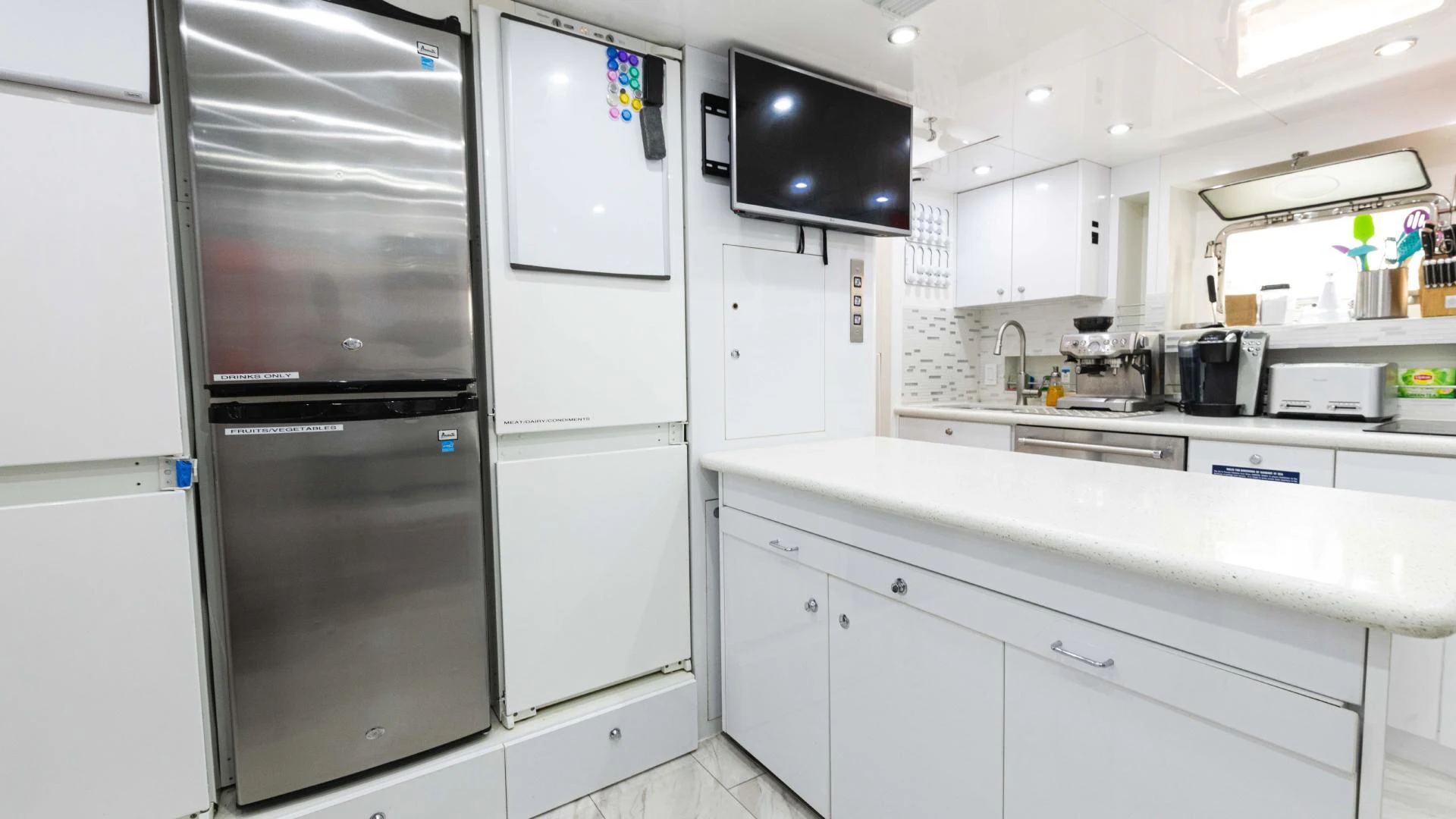 a kitchen with white cabinets aboard ARTHUR’S WAY Yacht for Sale