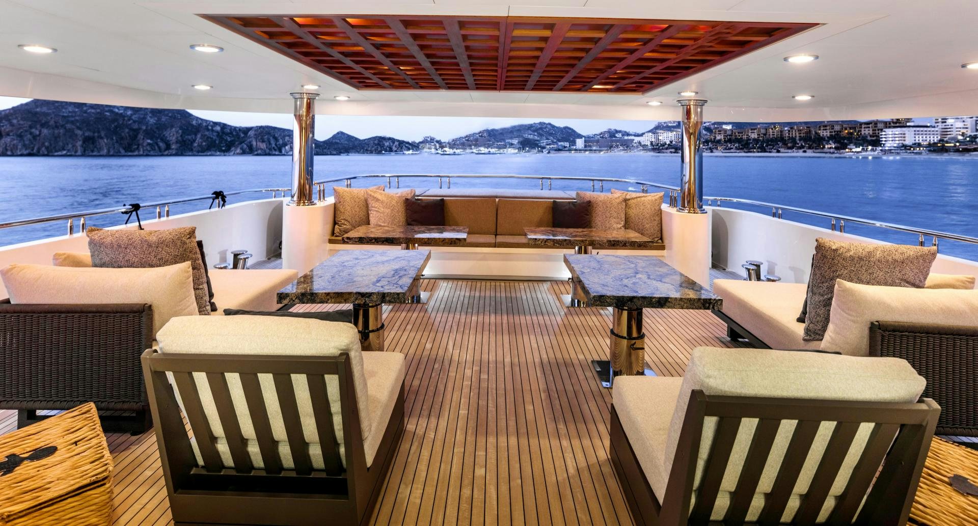 a large lounge area with a large body of water and a city in the background aboard CHAMPAGNE SEAS Yacht for Sale