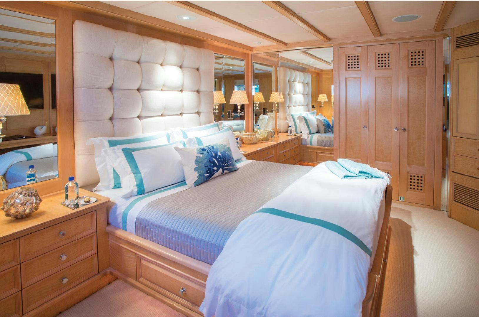 a bedroom with a bed and a mirror aboard RHINO Yacht for Sale