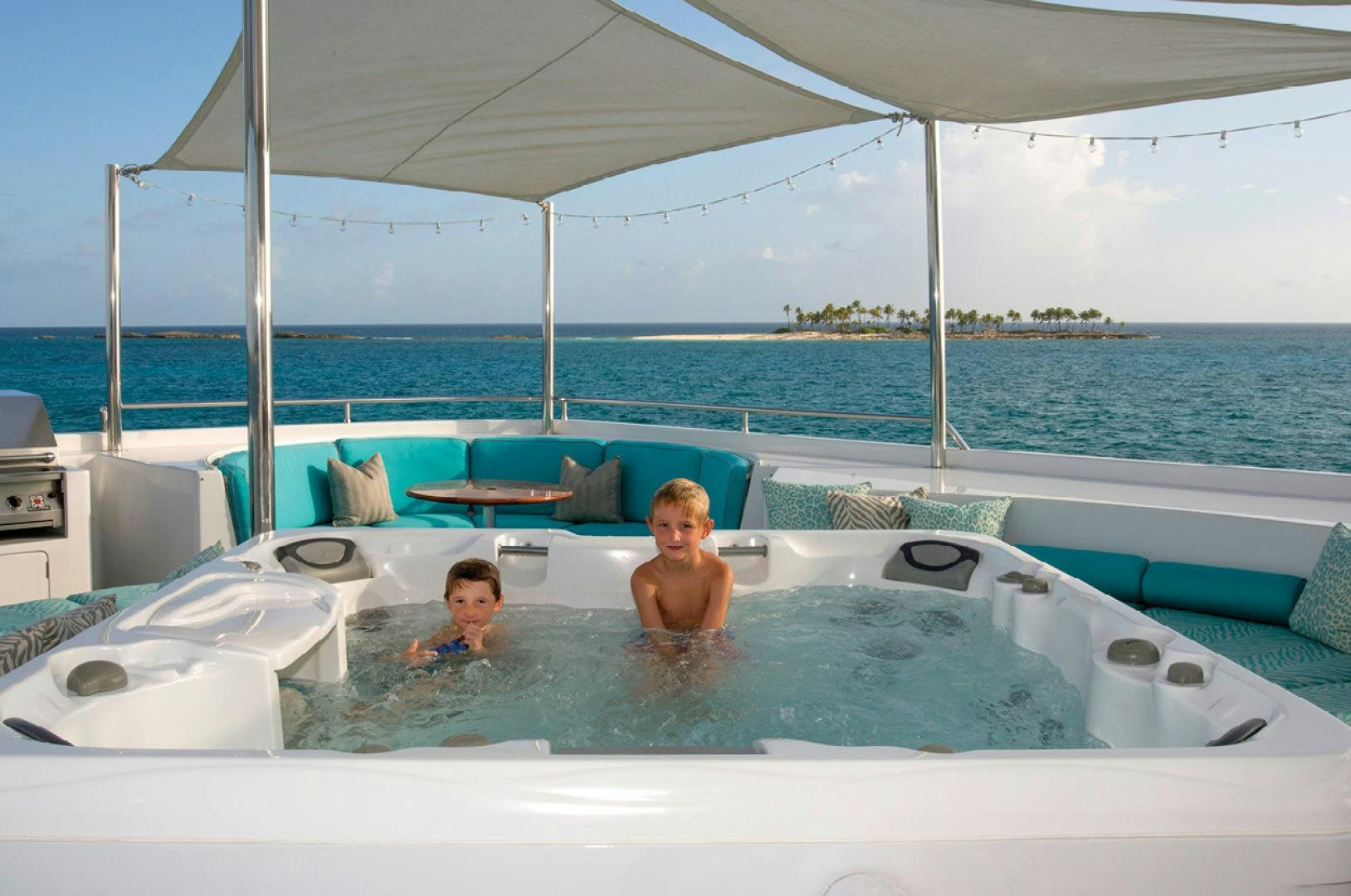 two boys sitting in a swimming pool aboard RHINO Yacht for Sale