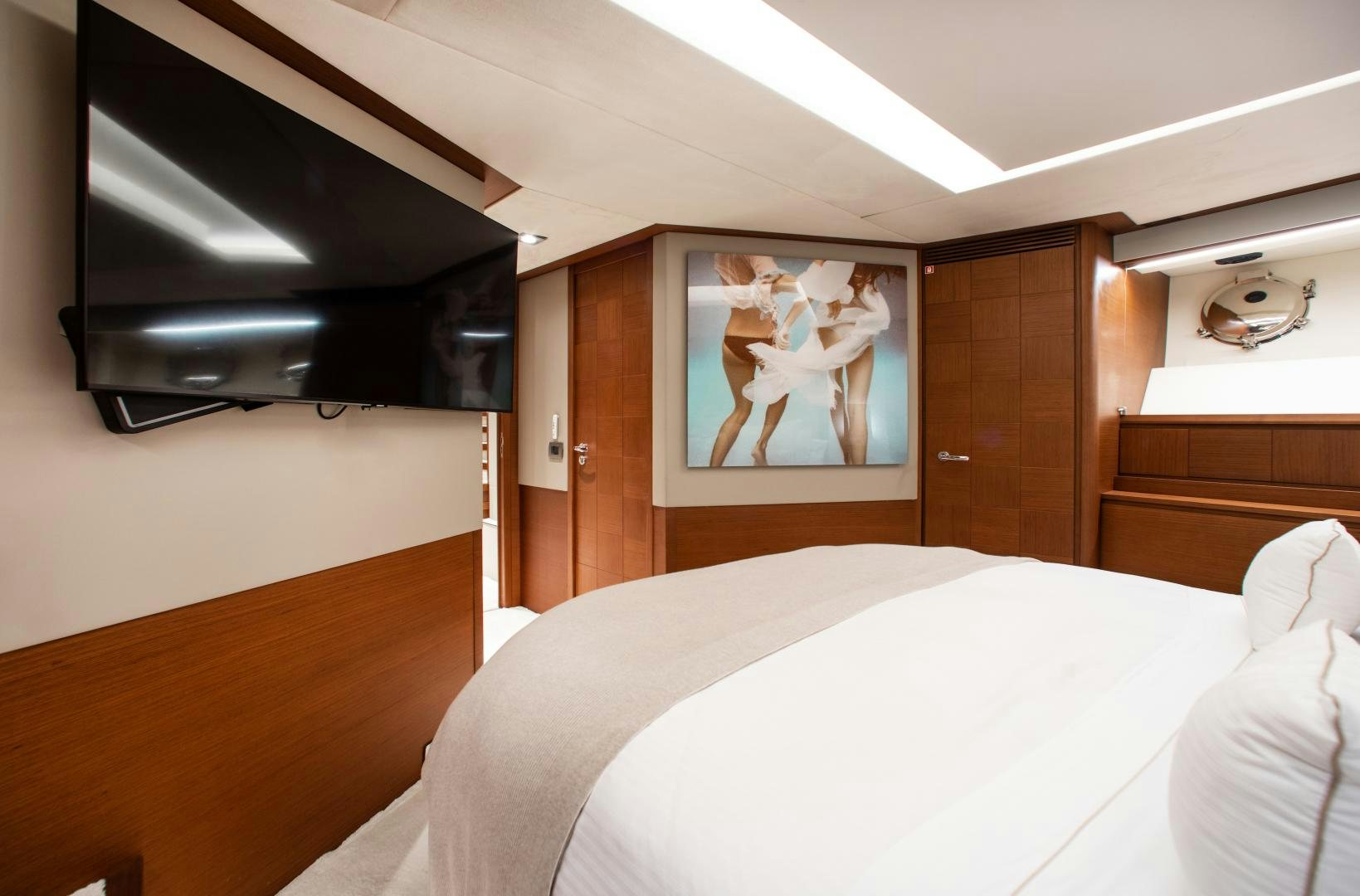 a bed with a television on the wall aboard ARREEE! Yacht for Sale
