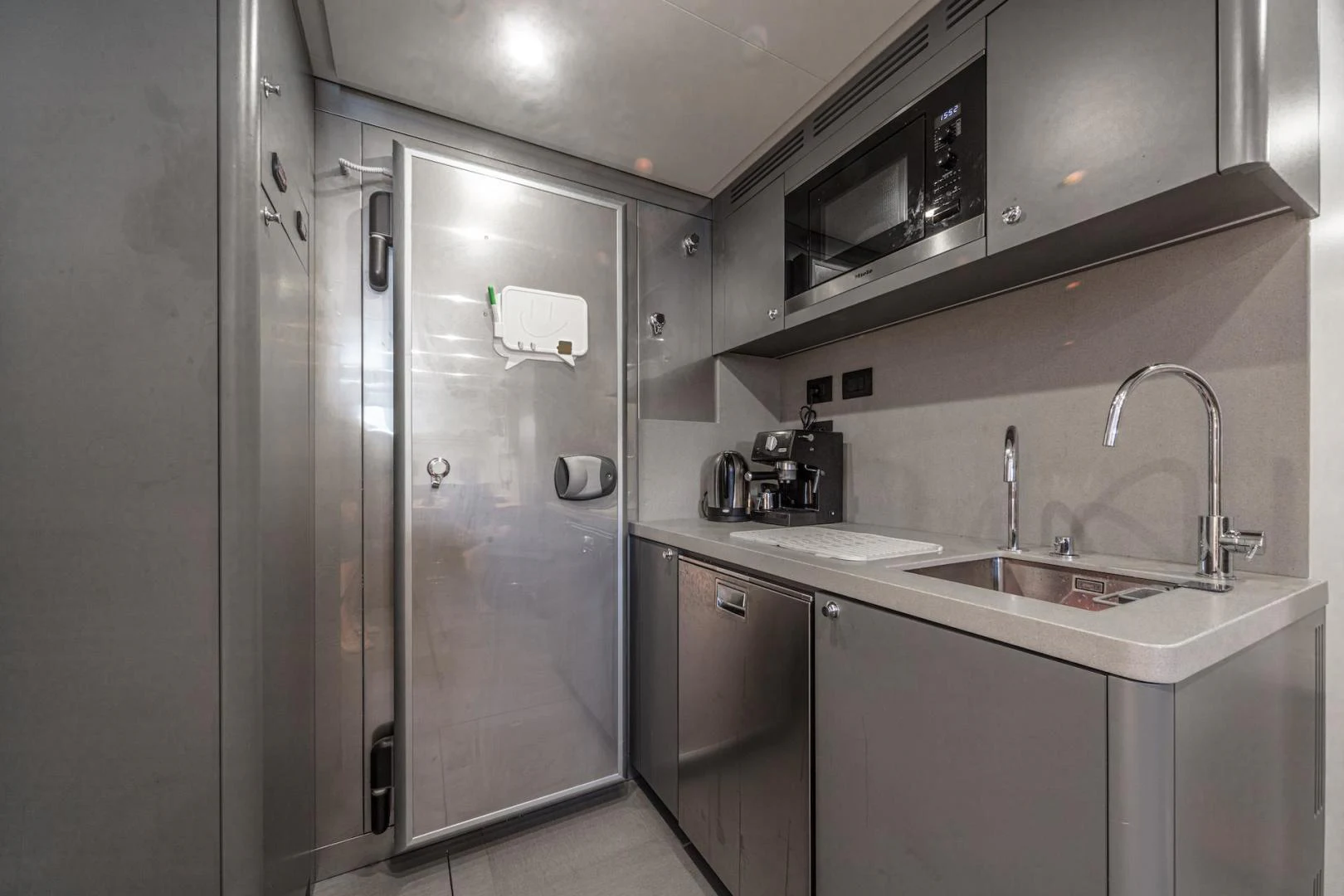 a kitchen with a stainless steel refrigerator aboard ATOM Yacht for Sale
