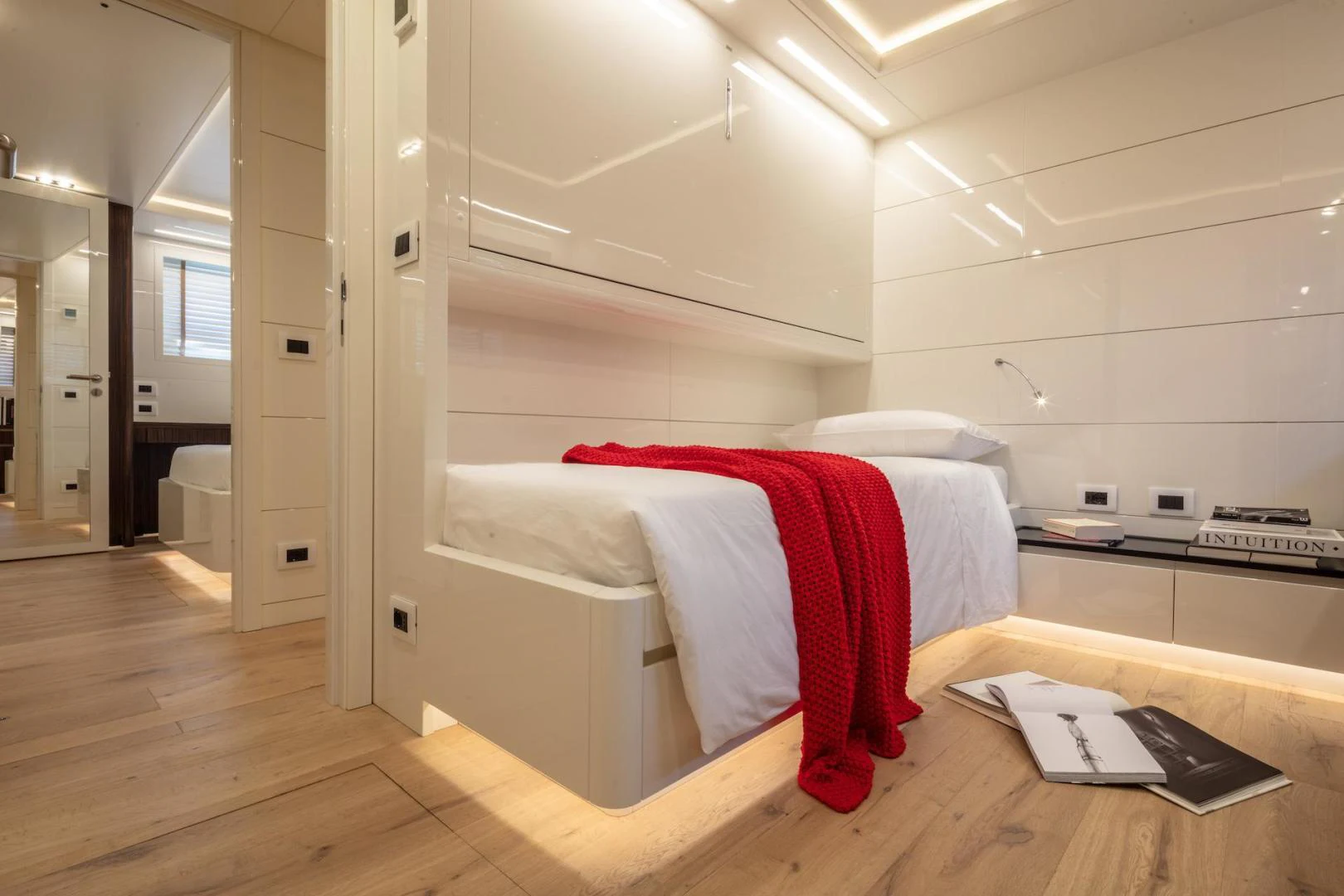 a bed with a red sheet on it aboard ATOM Yacht for Sale