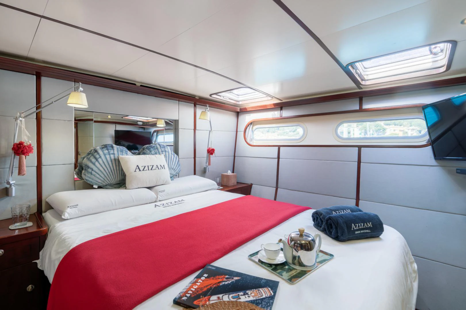 a bed with a white sheet and pillows on it aboard AZIZAM Yacht for Sale