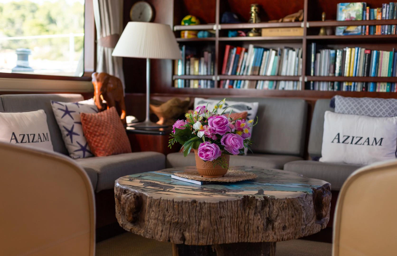 a living room with a table and couches aboard AZIZAM Yacht for Sale