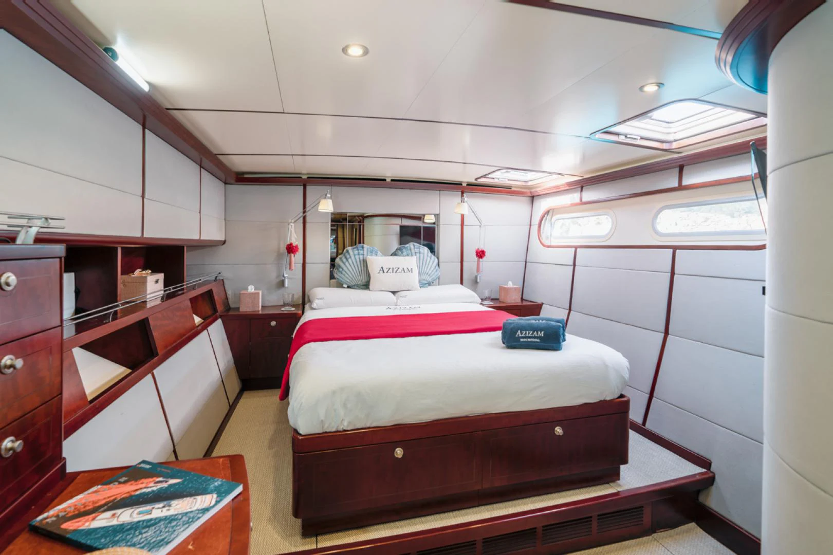 a bedroom with a bed and desk aboard AZIZAM Yacht for Sale