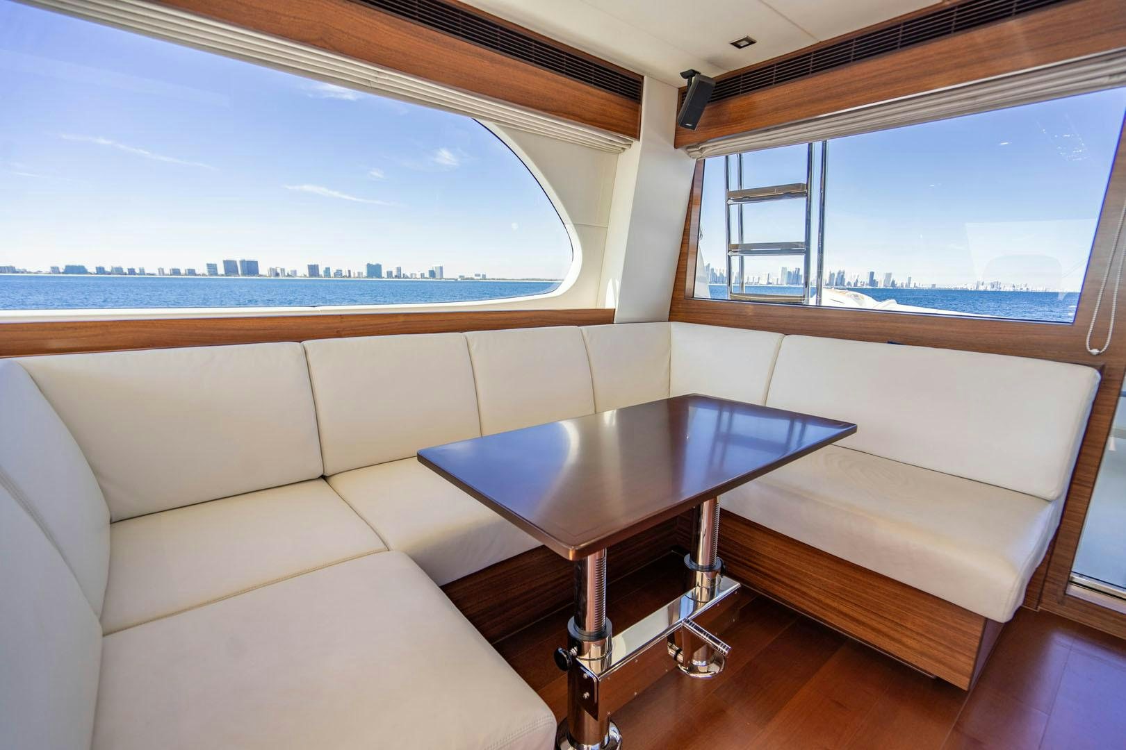 a table and a couch in a room with a window aboard LIFE Yacht for Sale