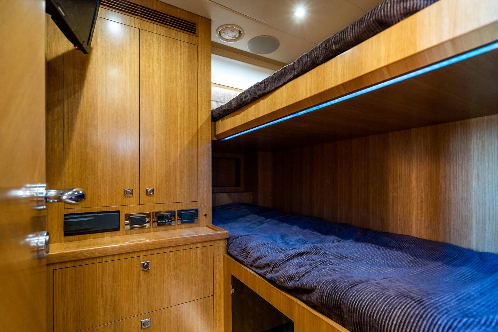 a room with a bed and a television aboard LIFE Yacht for Sale