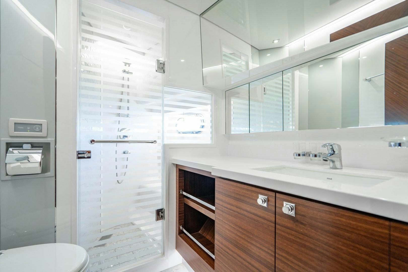 a white bathroom with a glass door aboard LIFE Yacht for Sale