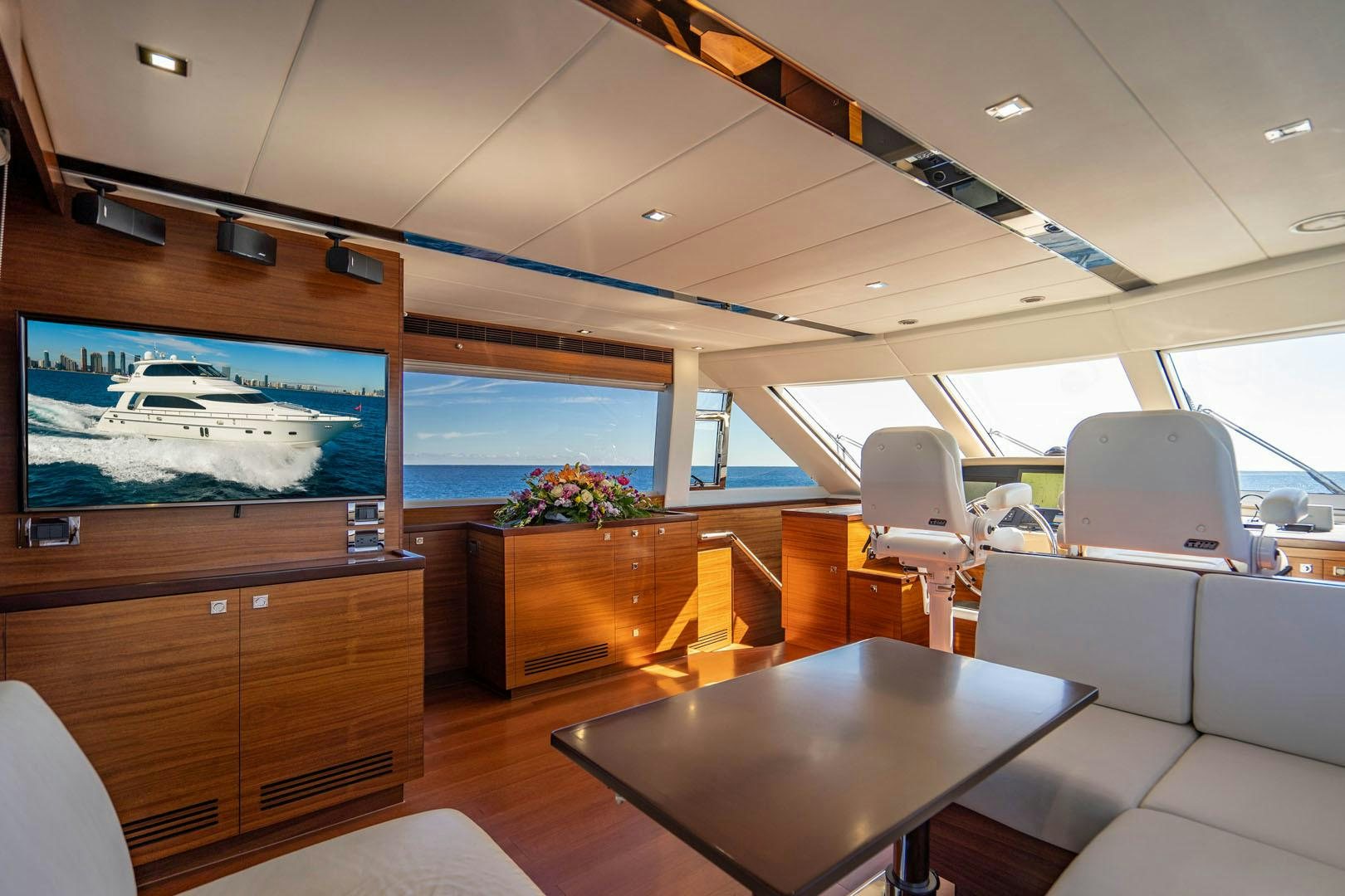 inside of a vehicle with a large screen and chairs and tables aboard LIFE Yacht for Sale