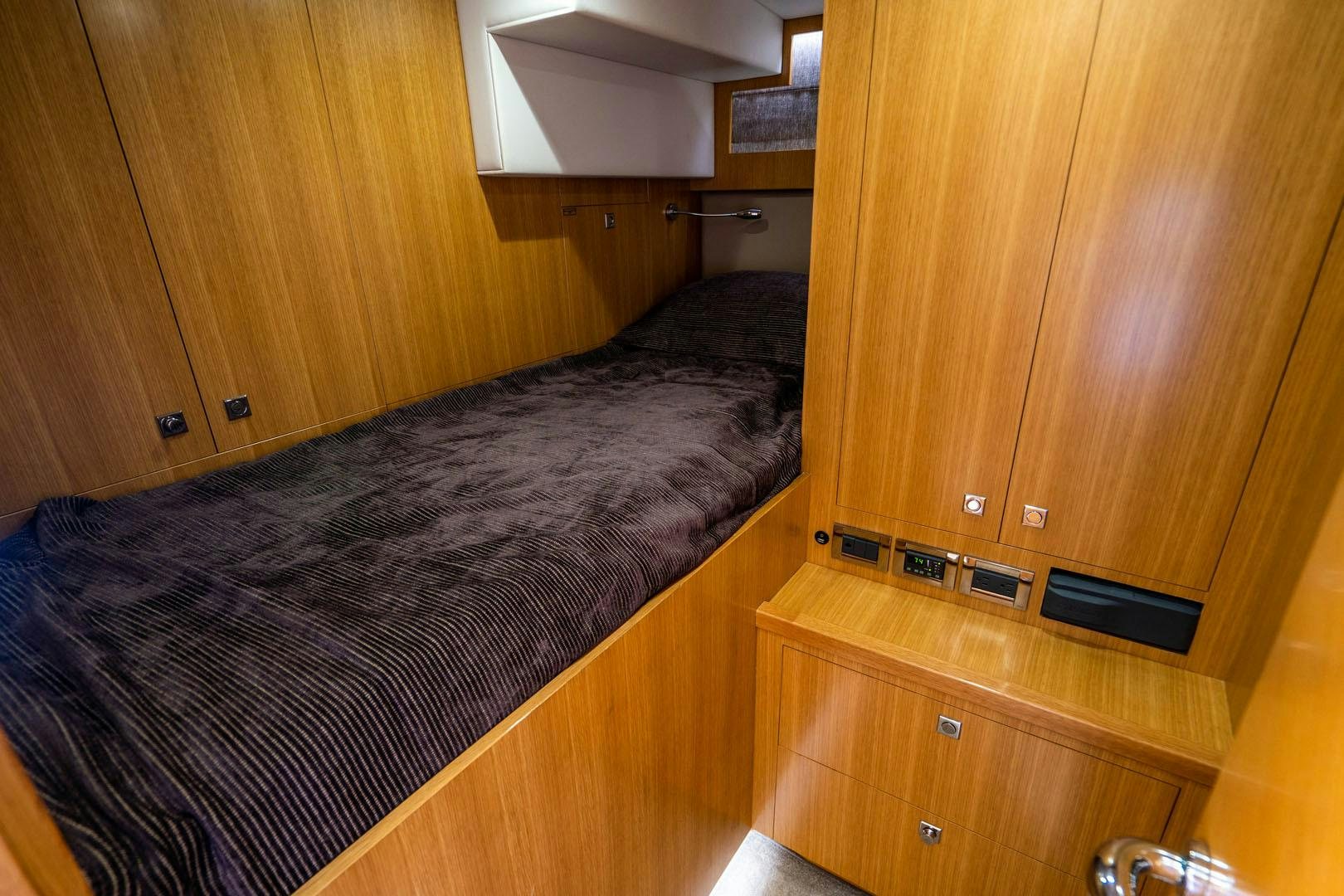 a bedroom with wood furniture aboard LIFE Yacht for Sale