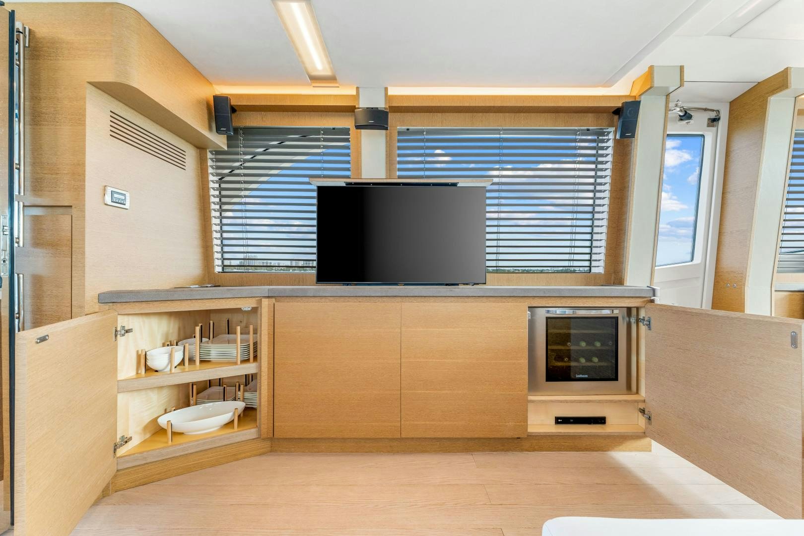 a room with a tv and a shelf with books on it aboard MONTE CARLO Yacht for Sale