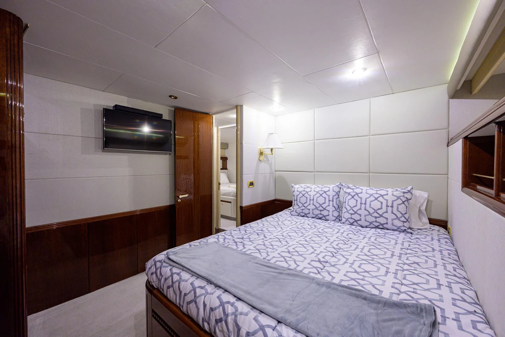 a bedroom with a bed and a television aboard TRYST Yacht for Sale