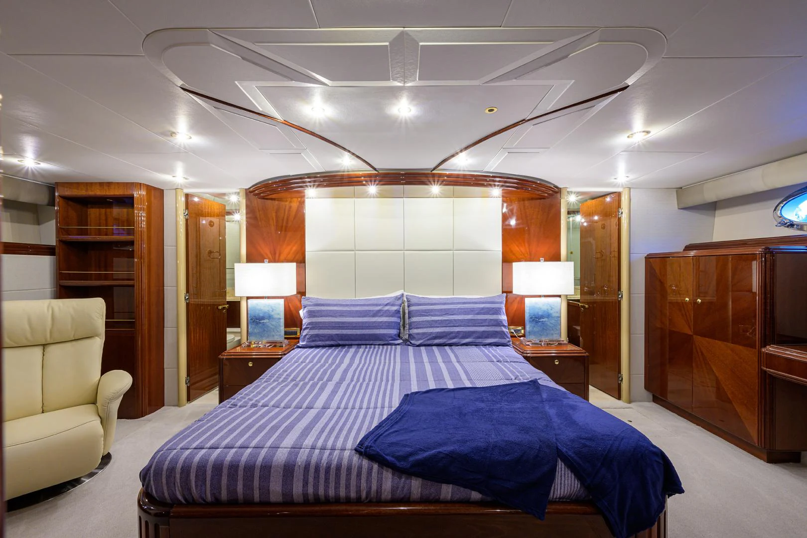 a bedroom with a bed and a chair aboard TRYST Yacht for Sale