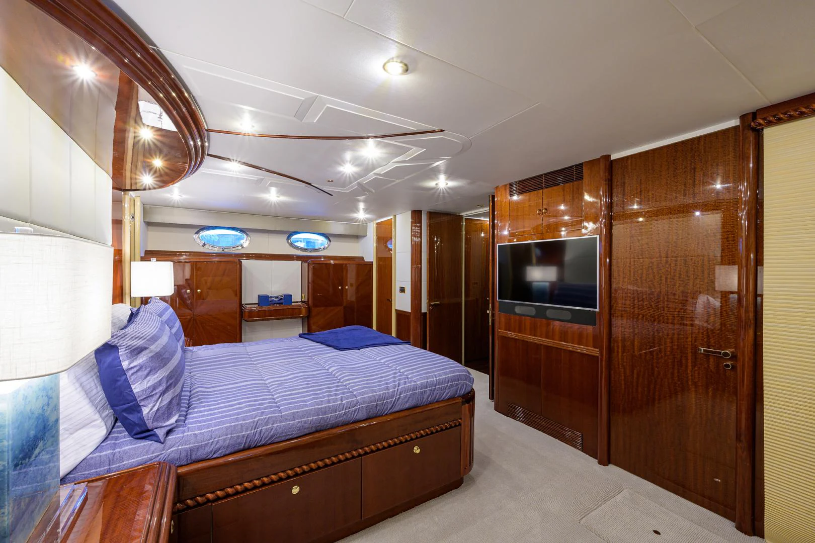 a room with a bed and a television aboard TRYST Yacht for Sale