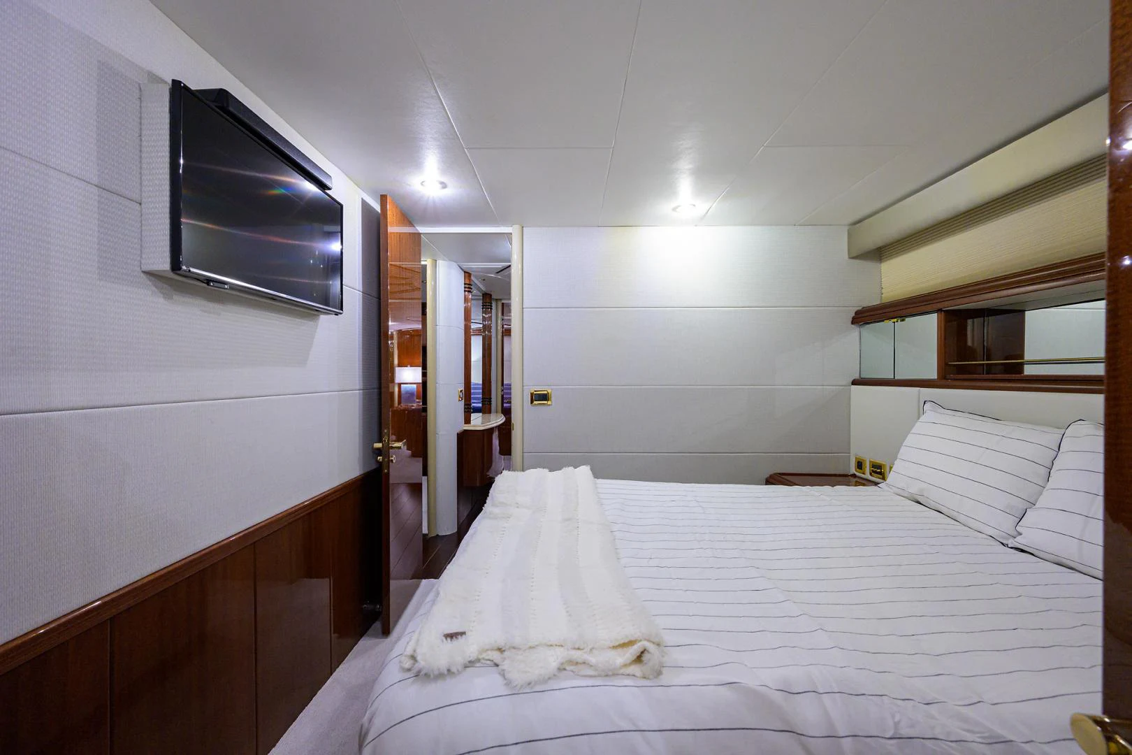 a room with a bed and a television on the wall aboard TRYST Yacht for Sale