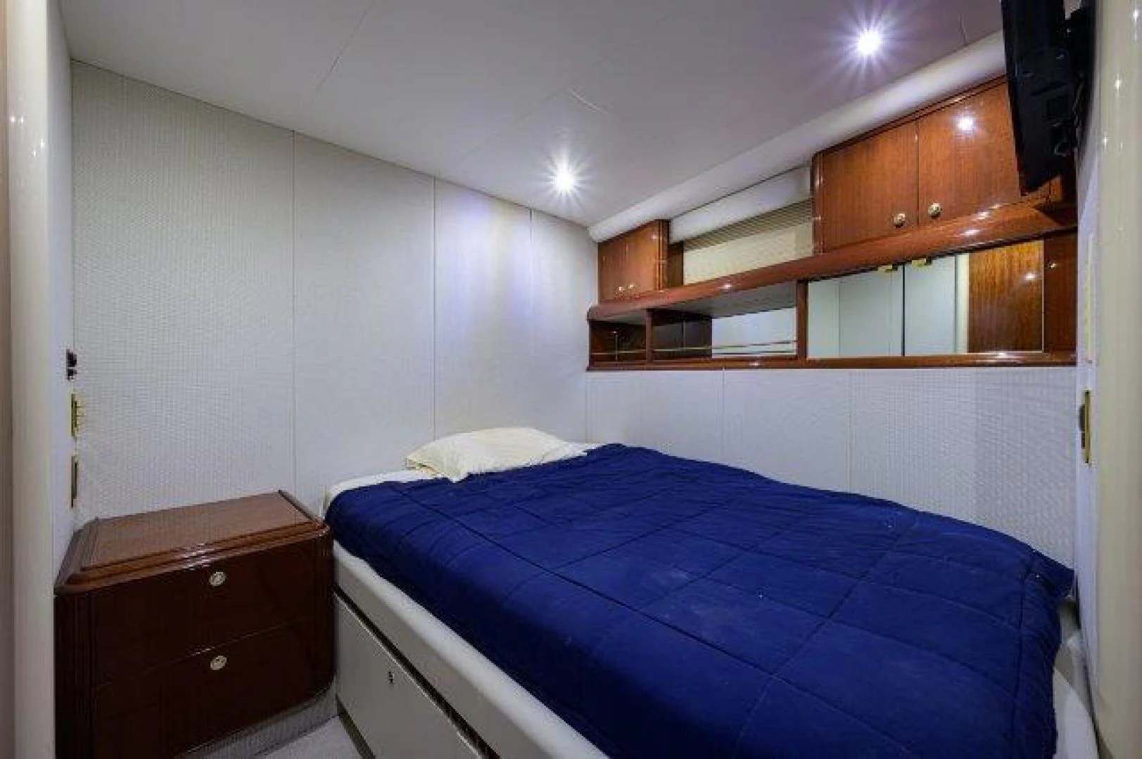 a bedroom with a bed and a dresser aboard TRYST Yacht for Sale