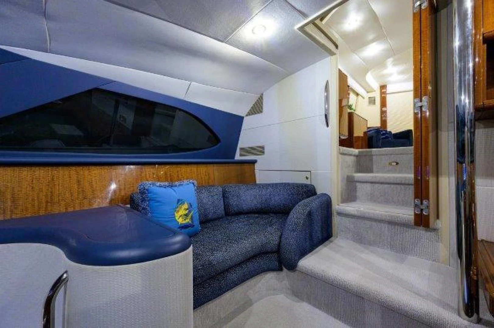 a living room with a blue couch aboard TRYST Yacht for Sale