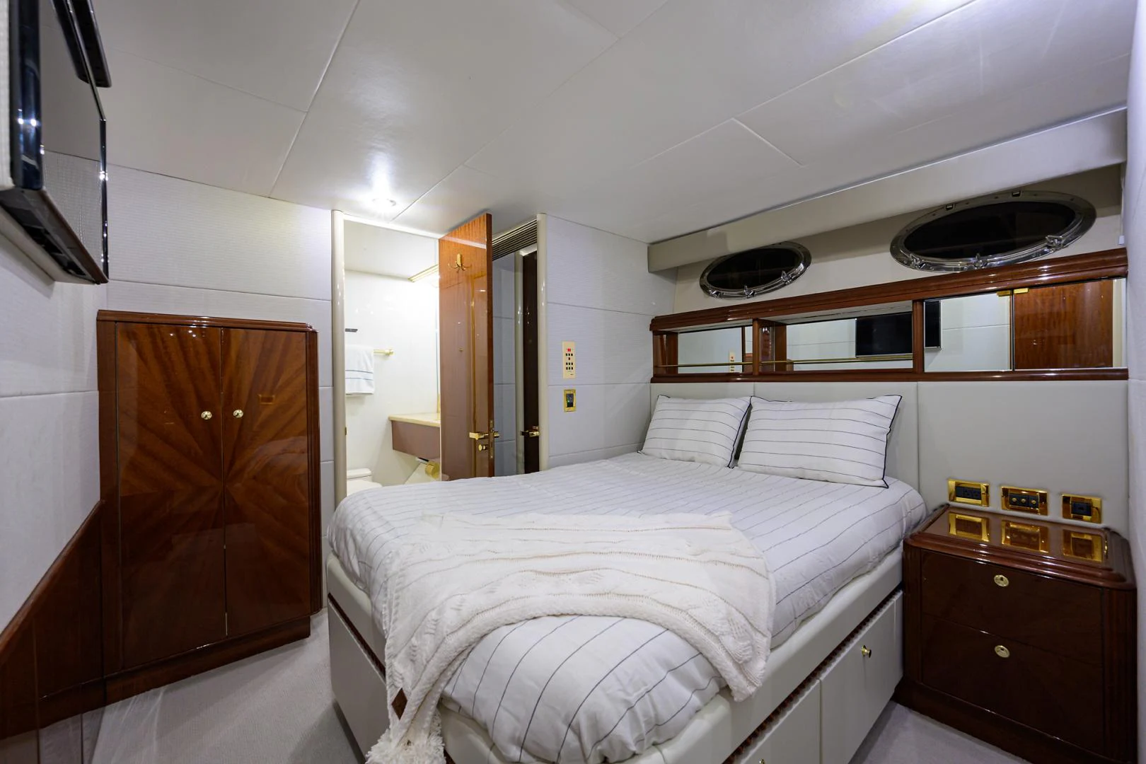 a bedroom with a bed and a television aboard TRYST Yacht for Sale