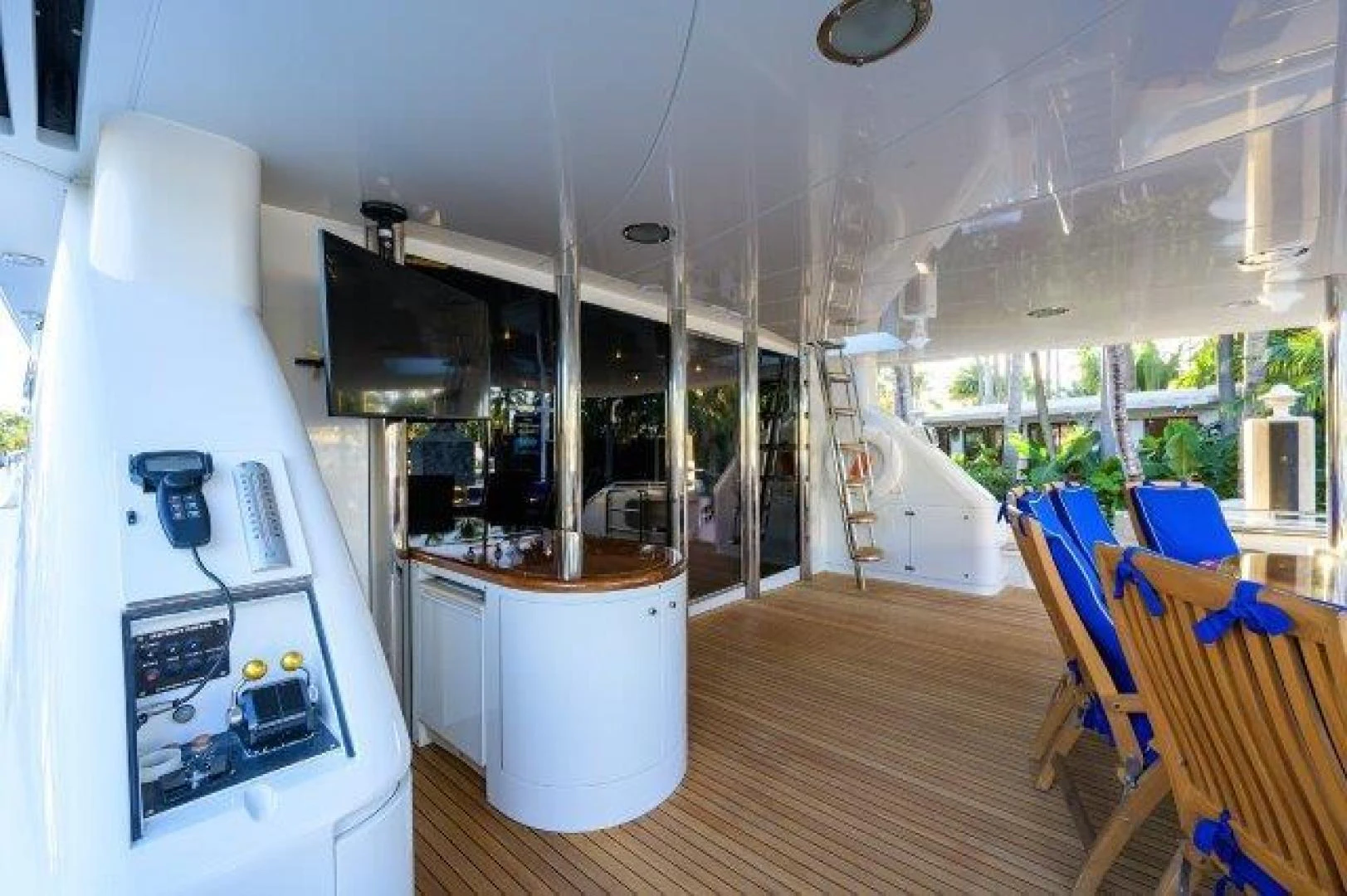 a room with a large window and a table with chairs and a television aboard TRYST Yacht for Sale