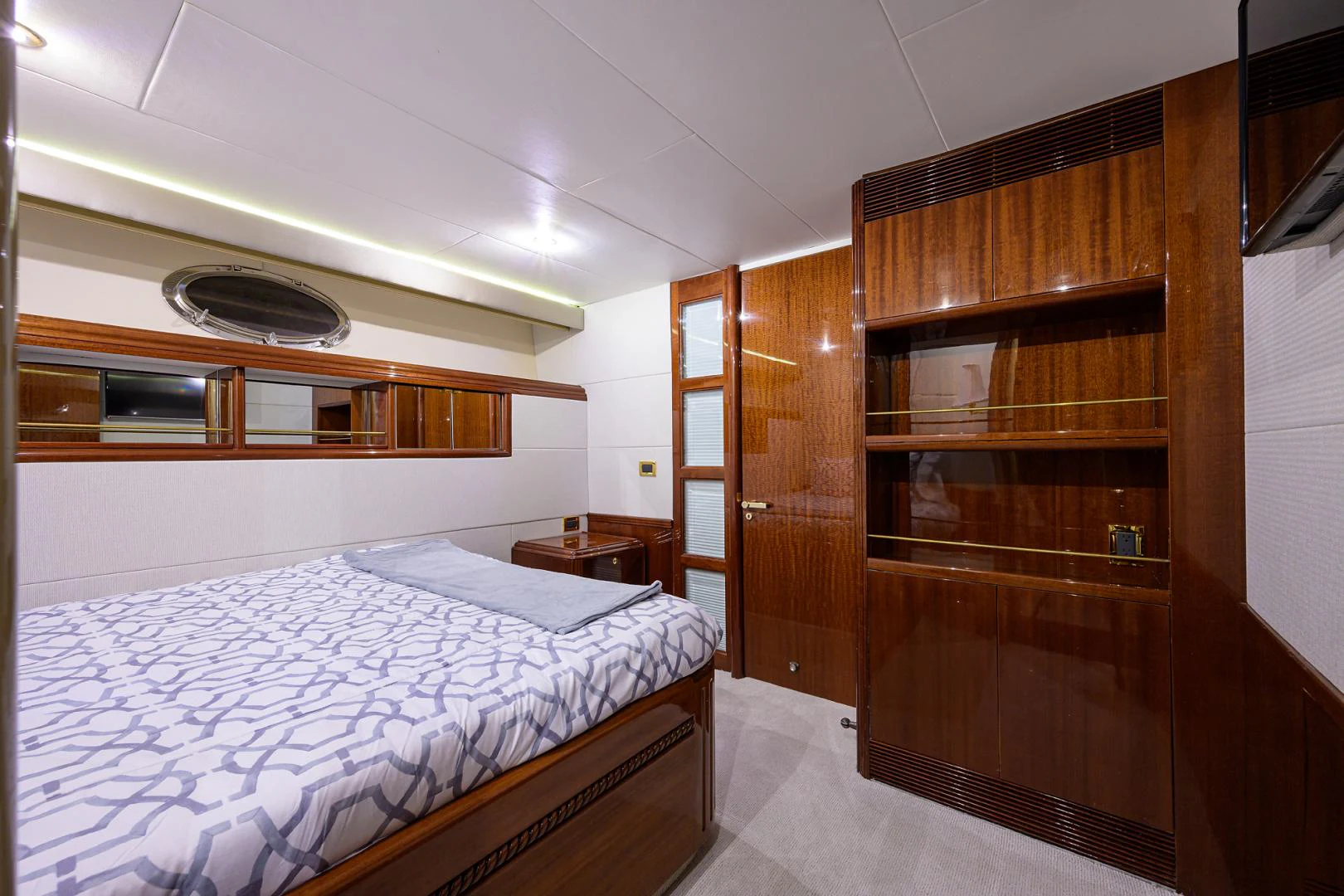 a room with a bed and a wood cabinet aboard TRYST Yacht for Sale