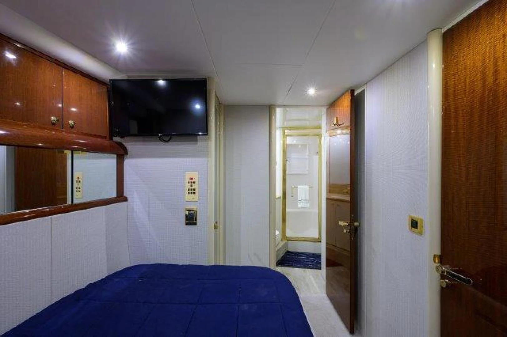 a bedroom with a blue bed aboard TRYST Yacht for Sale