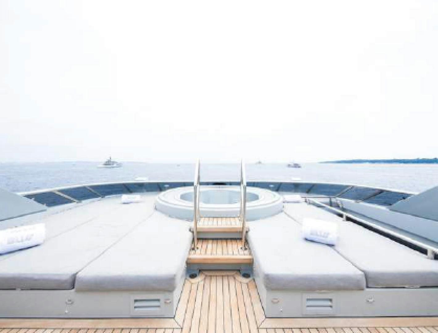 a deck with a railing and a boat on it aboard BLISS Yacht for Sale