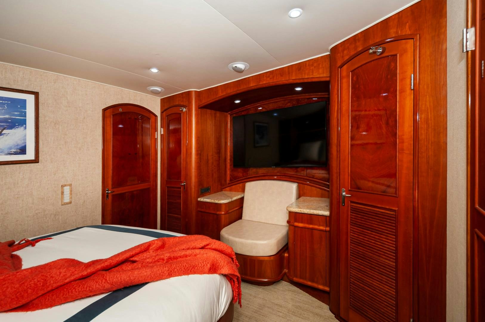 a bedroom with a bed and a wood cabinet aboard BANK ON Yacht for Sale