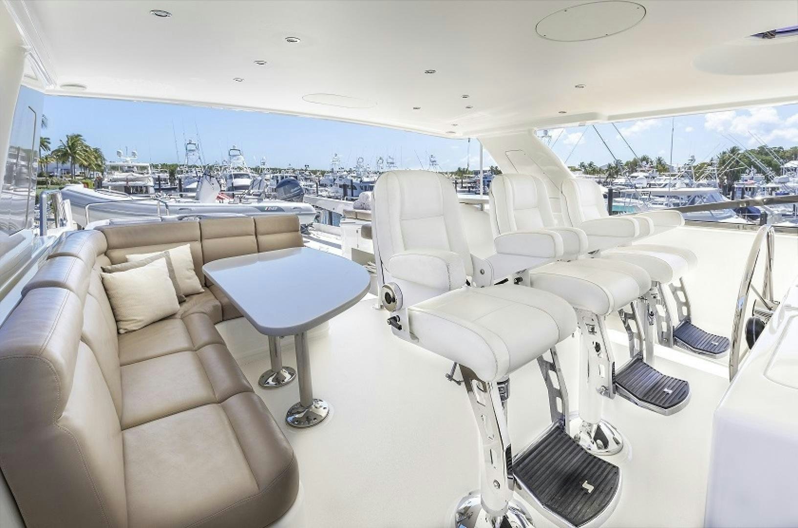 a room with a couch and a table with chairs and a view of the water aboard CHERRY BOMB Yacht for Sale