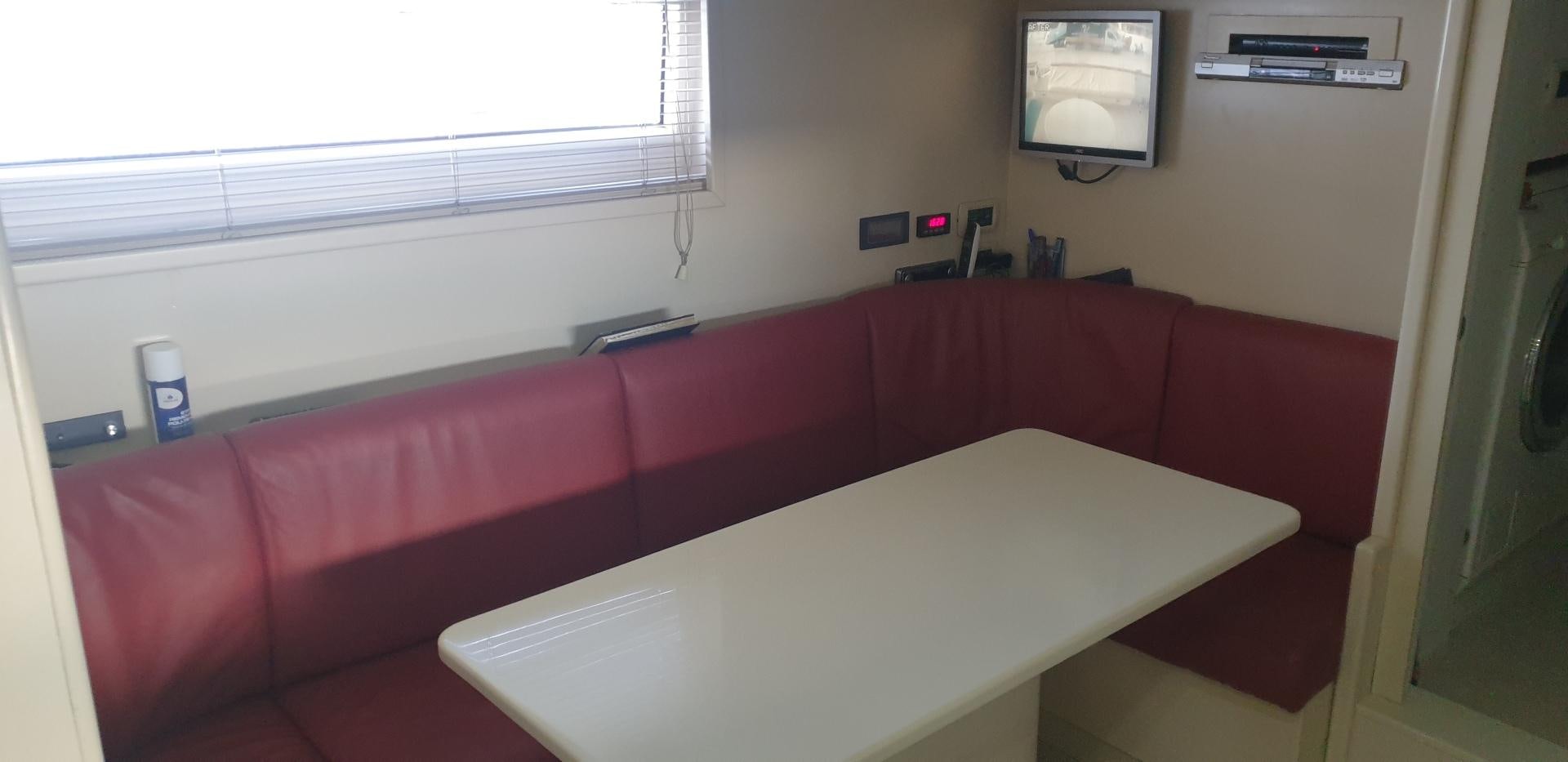 a red couch with a white table aboard TIGRA Yacht for Sale