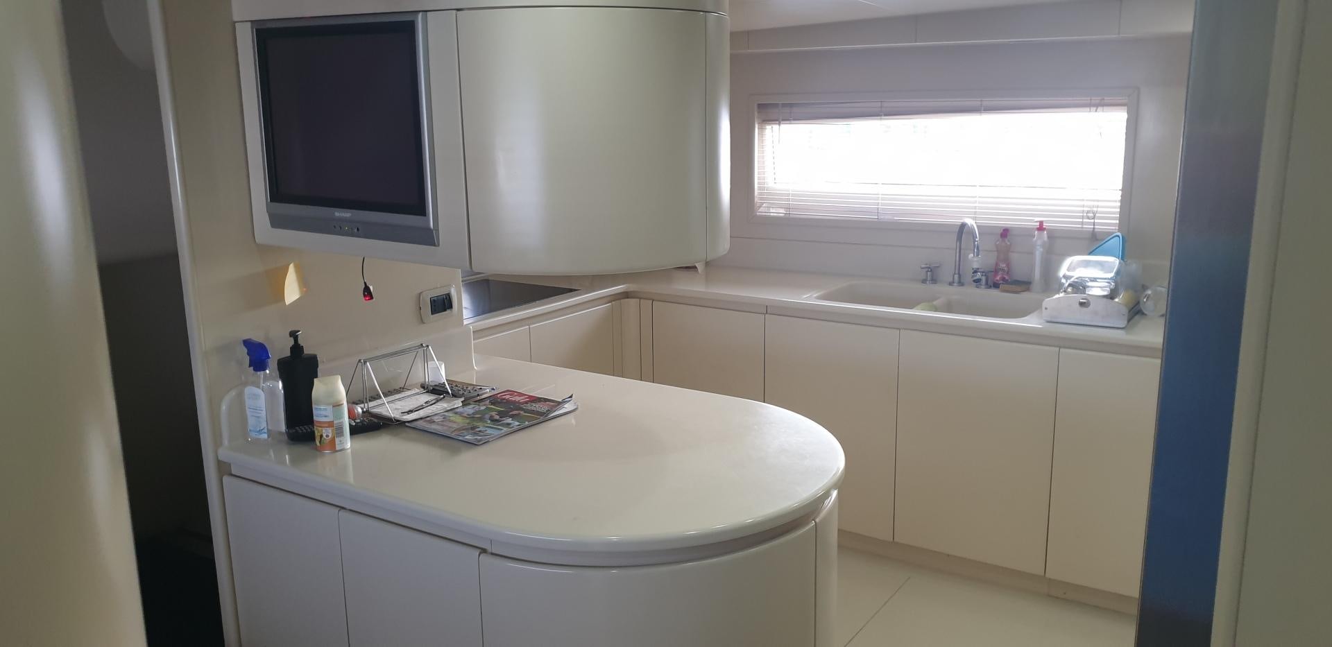 a kitchen with a sink and a tv on the wall aboard TIGRA Yacht for Sale