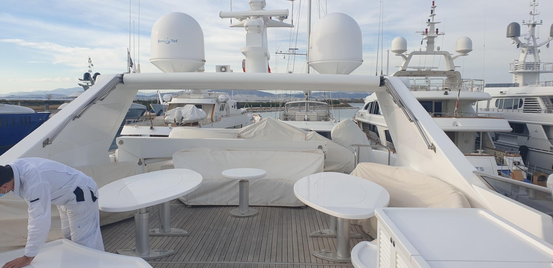 a person standing on a deck looking at a large white ship aboard TIGRA Yacht for Sale