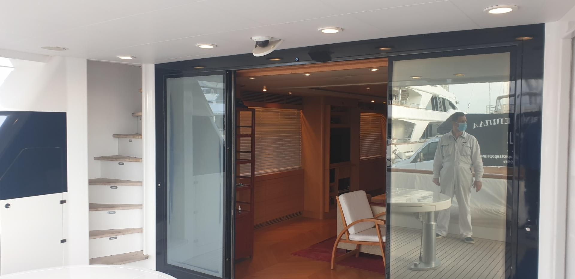 a person in a white suit walking through a doorway aboard TIGRA Yacht for Sale