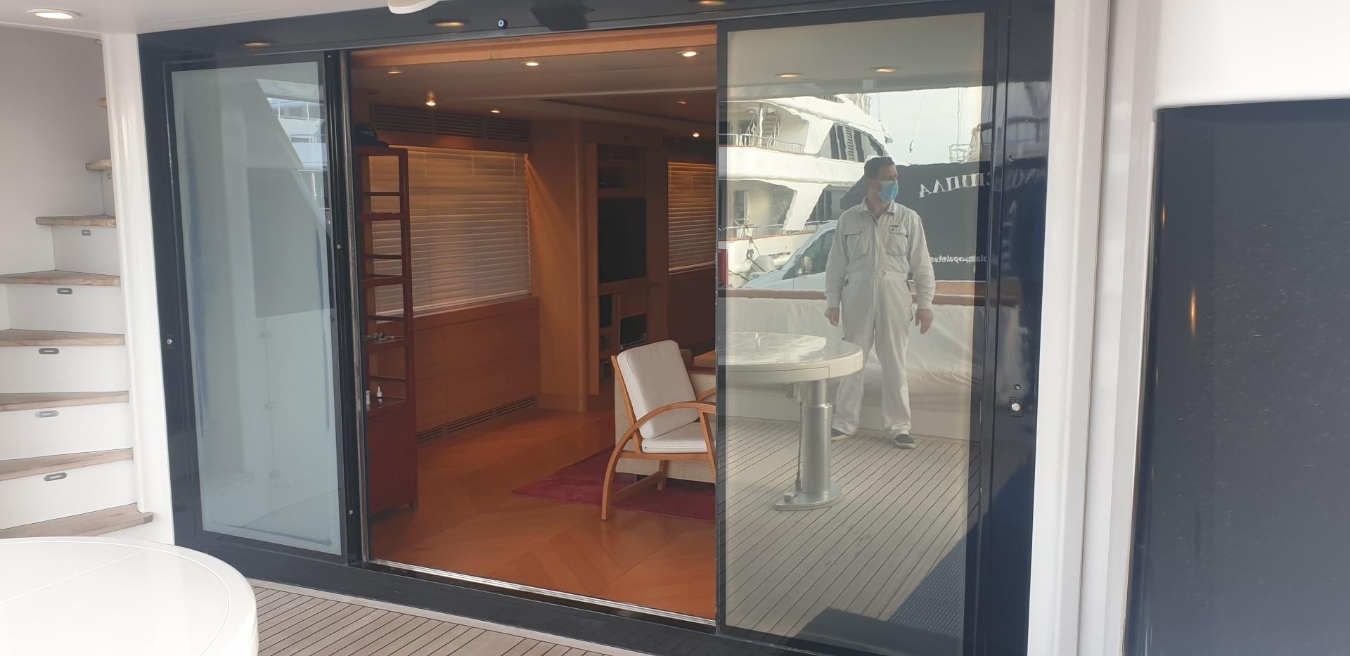 a person in a white coat walking through a doorway aboard TIGRA Yacht for Sale