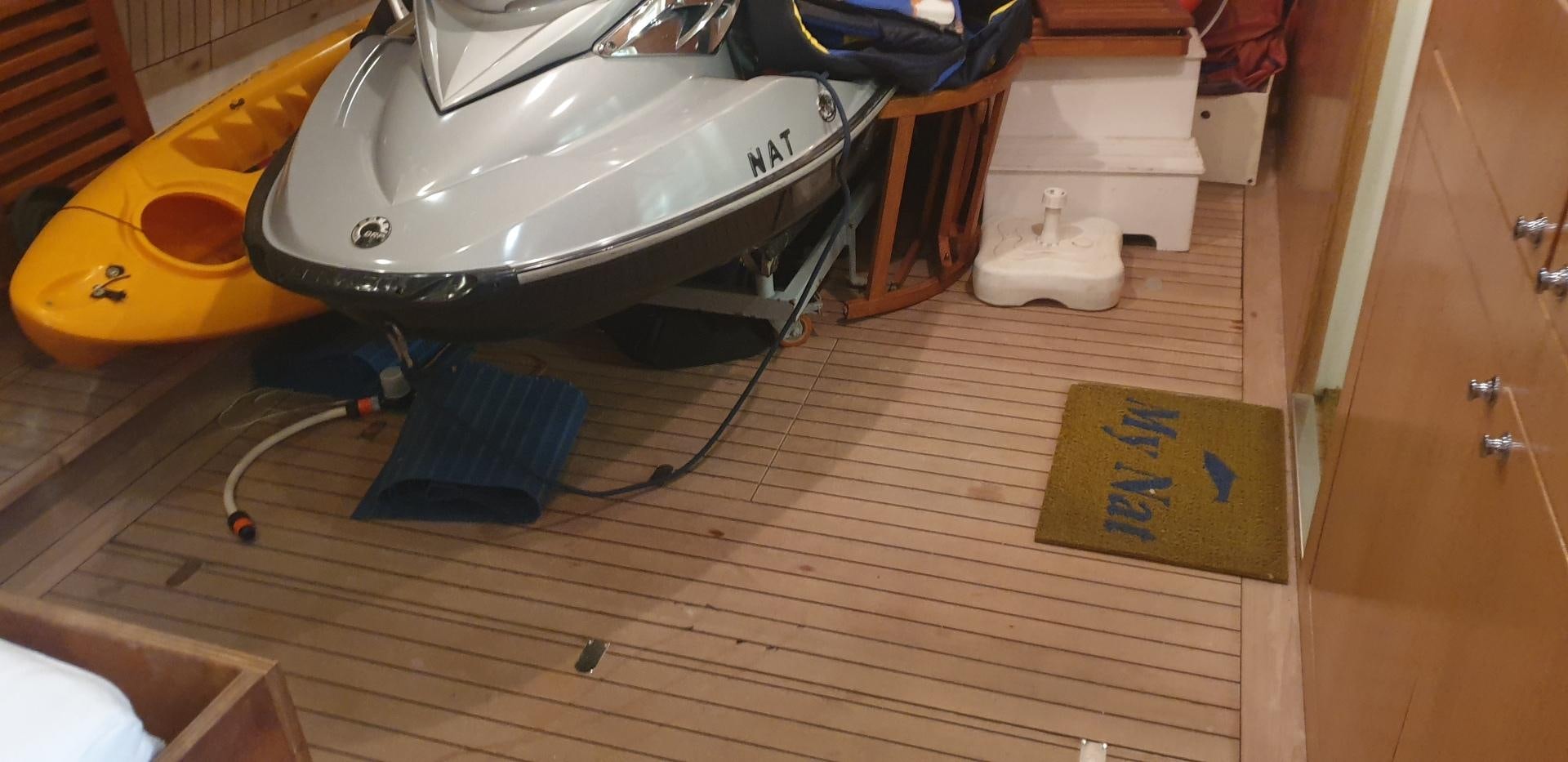 a white and orange boat on a wooden floor aboard TIGRA Yacht for Sale