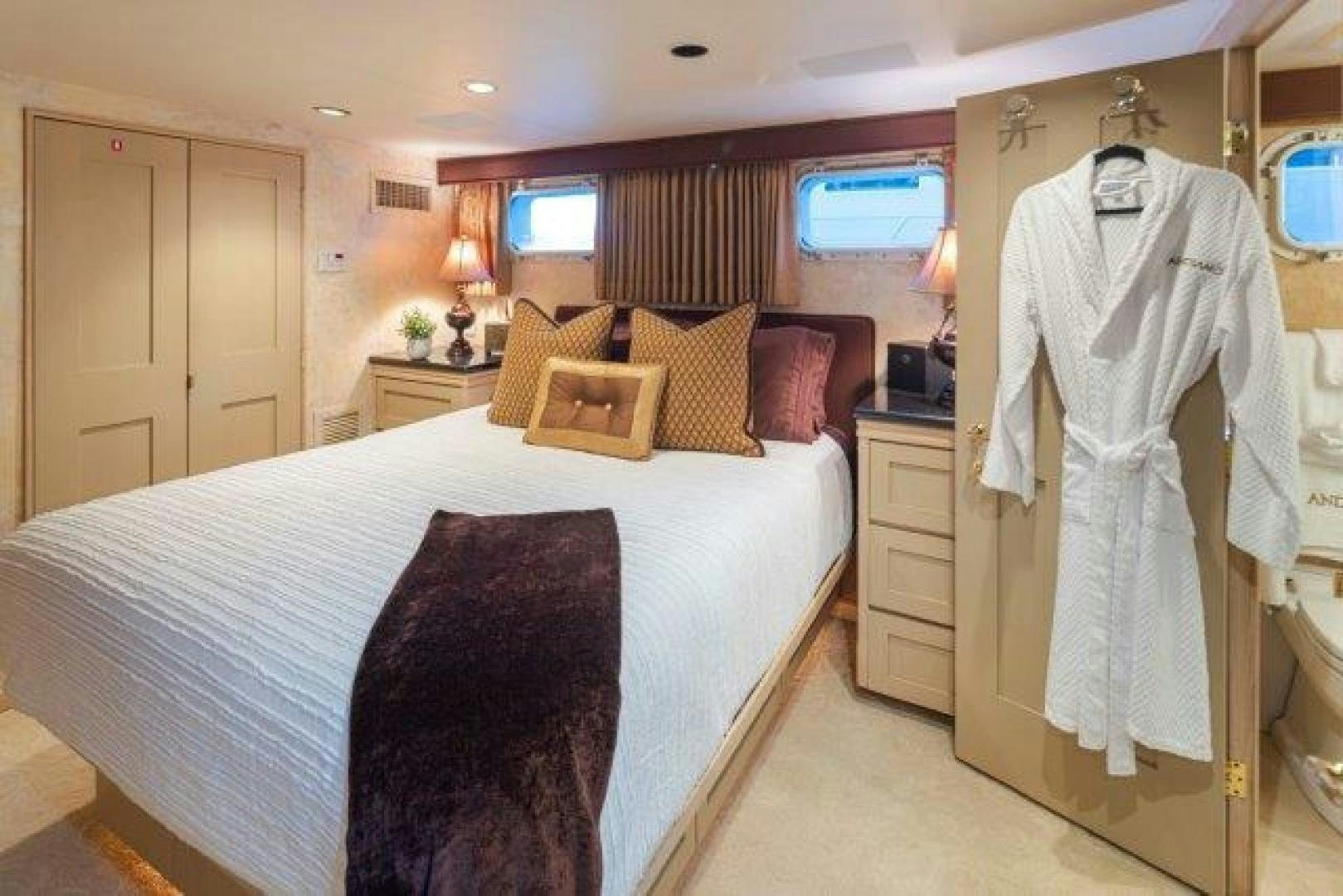 a bedroom with a bed and a robe on the wall aboard ANDIAMO Yacht for Sale