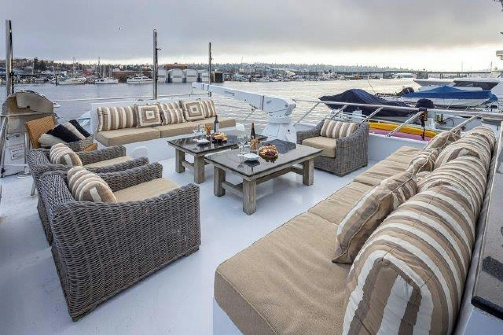 a group of couches and chairs on a deck overlooking a body of water aboard ANDIAMO Yacht for Sale