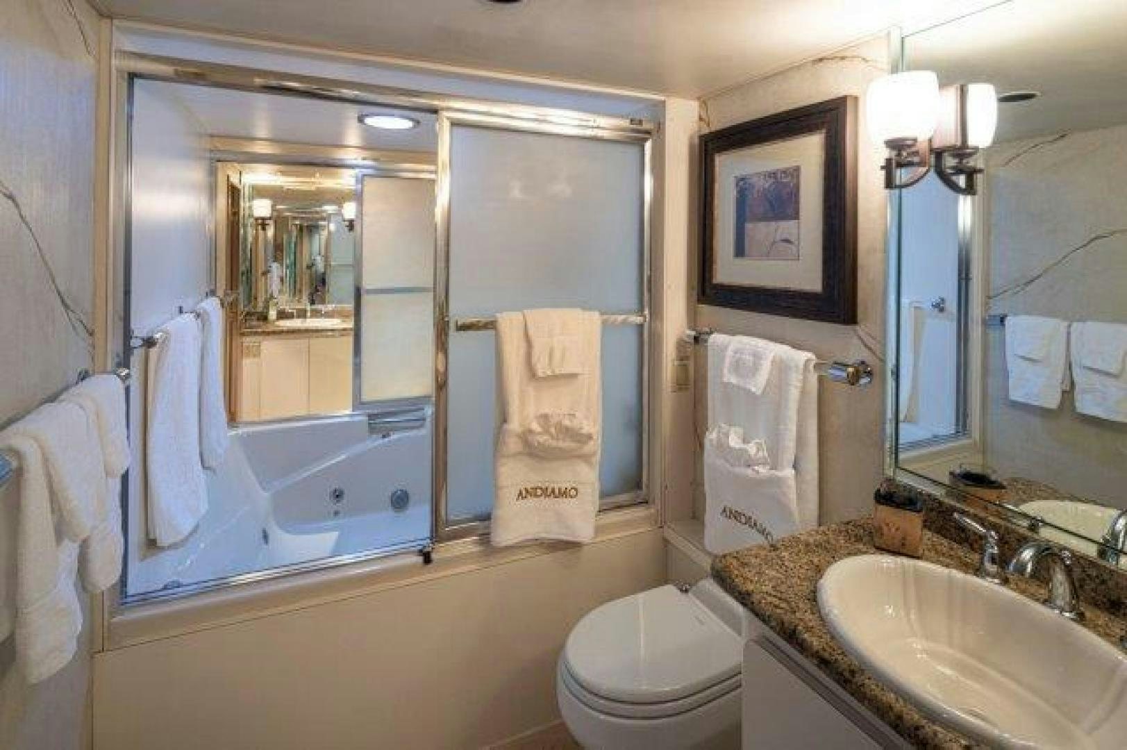 a bathroom with a tub sink and toilet aboard ANDIAMO Yacht for Sale