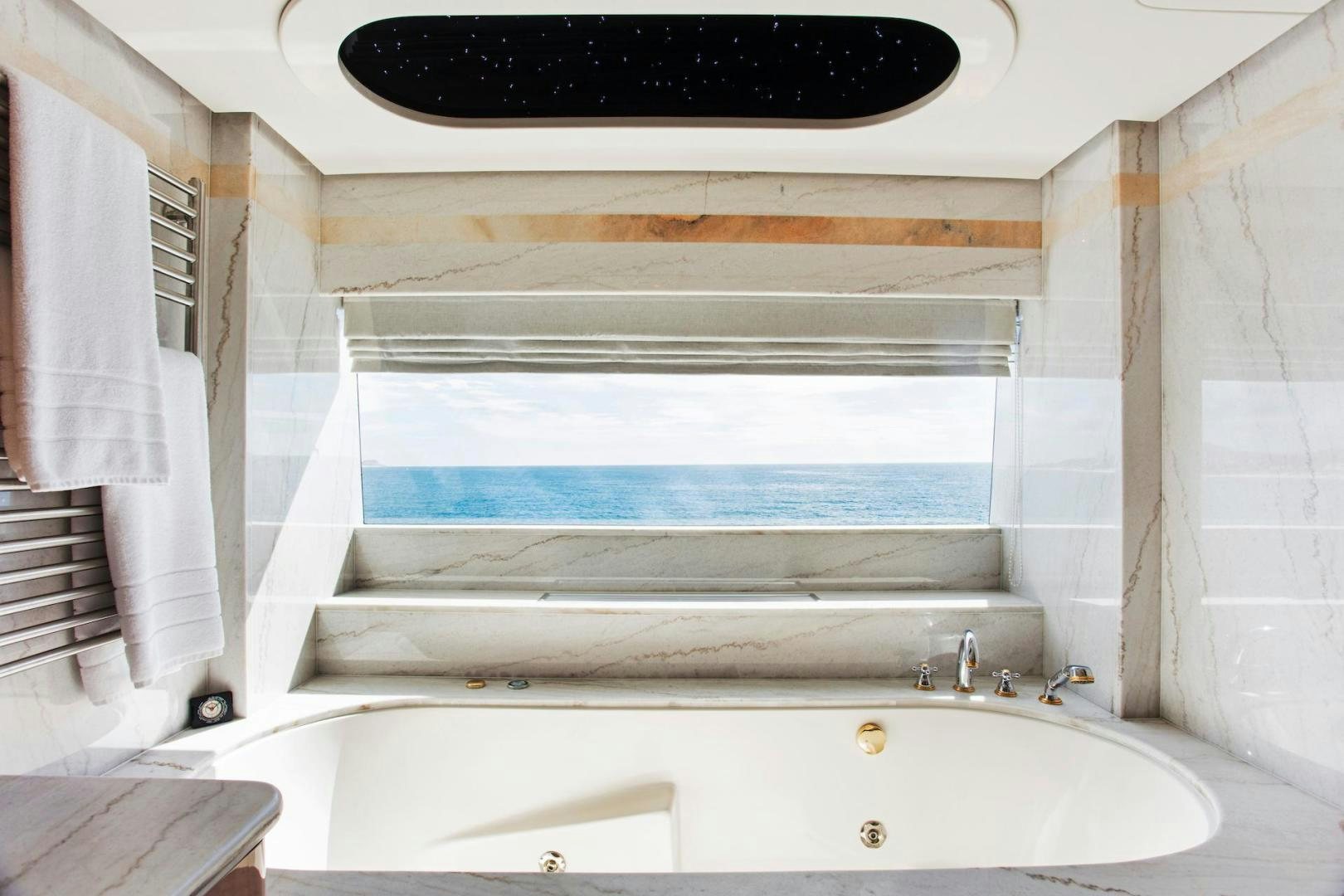 a bathtub with a sink and a window aboard STAY SALTY Yacht for Sale