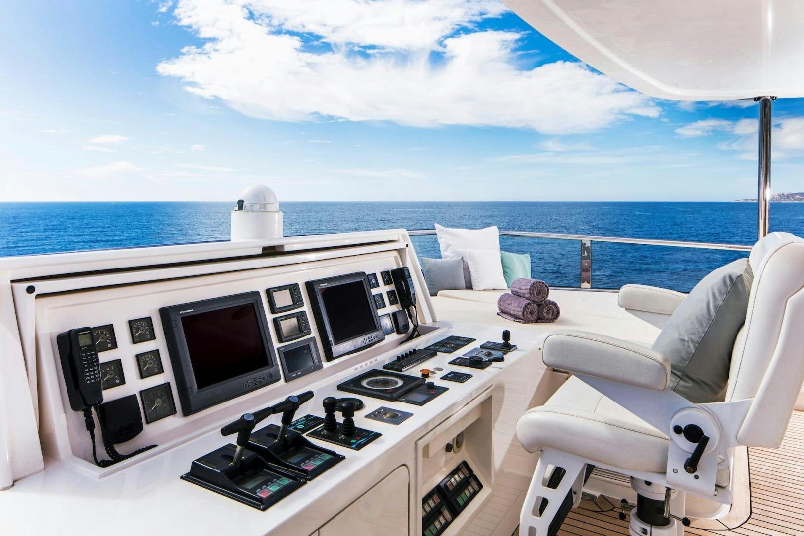a white living room with a large white sofa and a large white boat on a sunny day aboard STAY SALTY Yacht for Sale