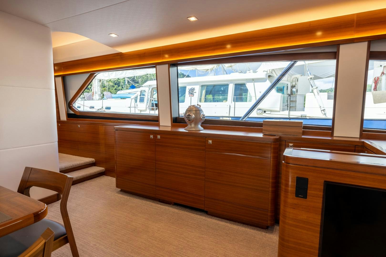 a room with a wood cabinet and a window with a view of a city aboard BONNY READ Yacht for Sale