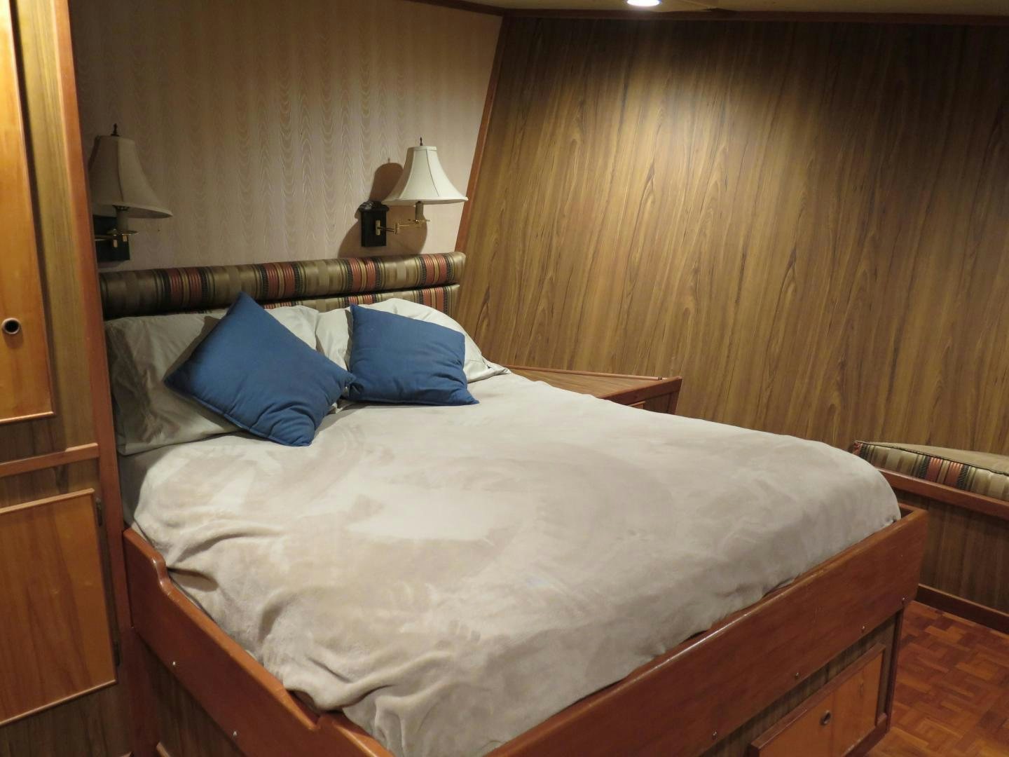 a bed with blue pillows aboard WANDERER Yacht for Sale