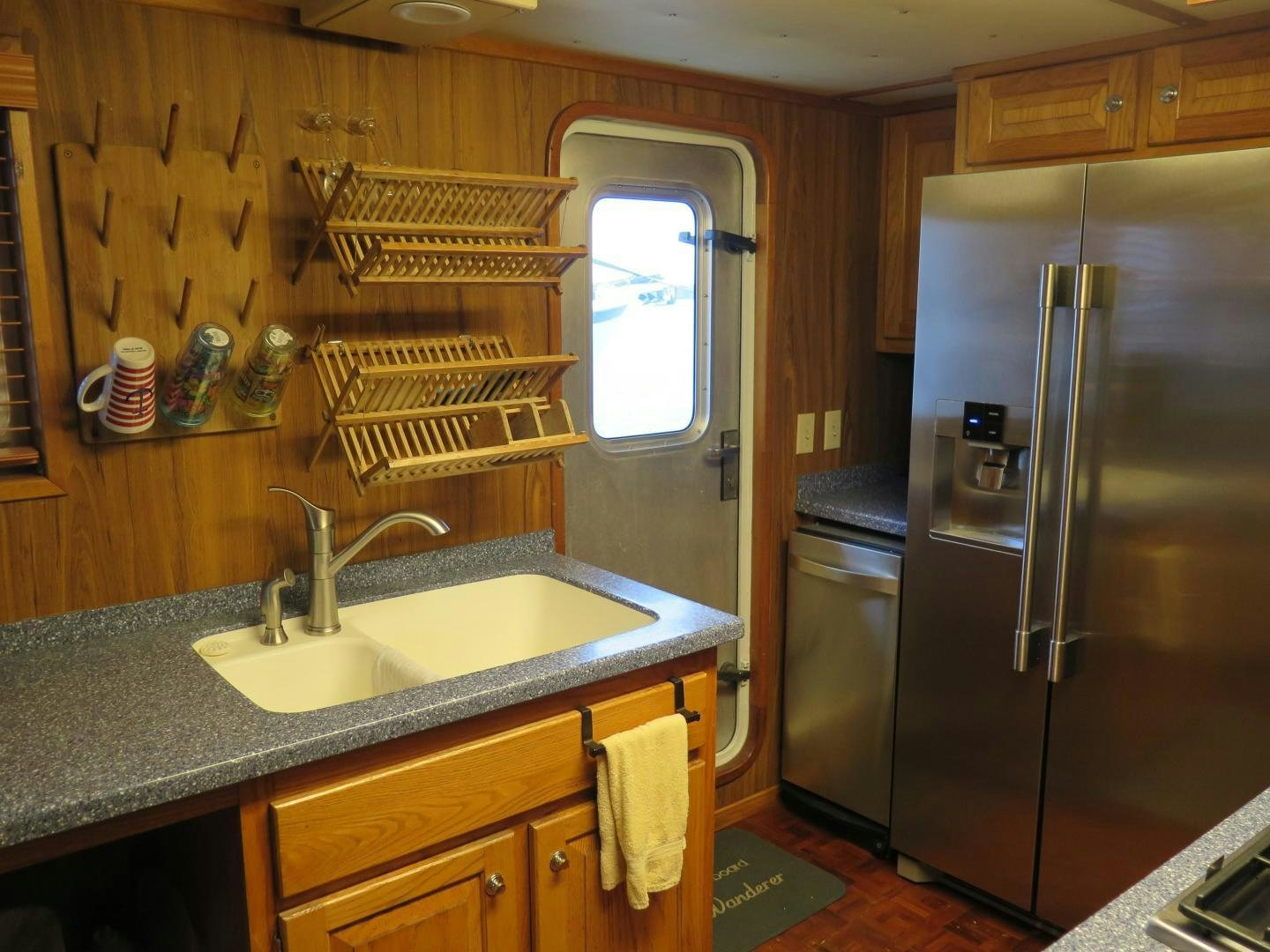 a kitchen with a stainless steel refrigerator aboard WANDERER Yacht for Sale
