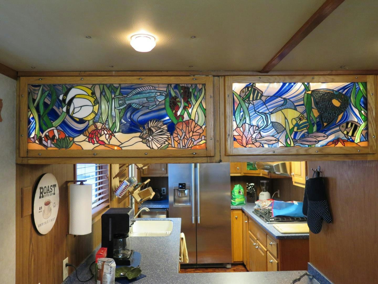 a kitchen with a refrigerator and a painting on the wall aboard WANDERER Yacht for Sale
