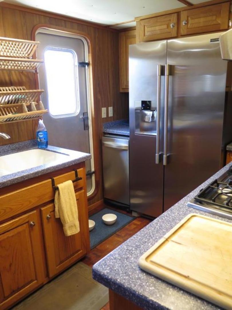 a kitchen with a stainless steel refrigerator aboard WANDERER Yacht for Sale