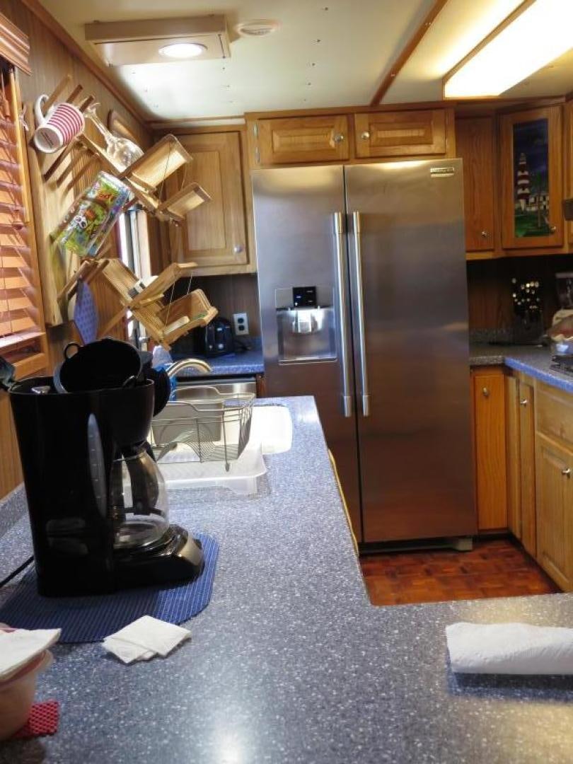 a kitchen with a stainless steel refrigerator aboard WANDERER Yacht for Sale