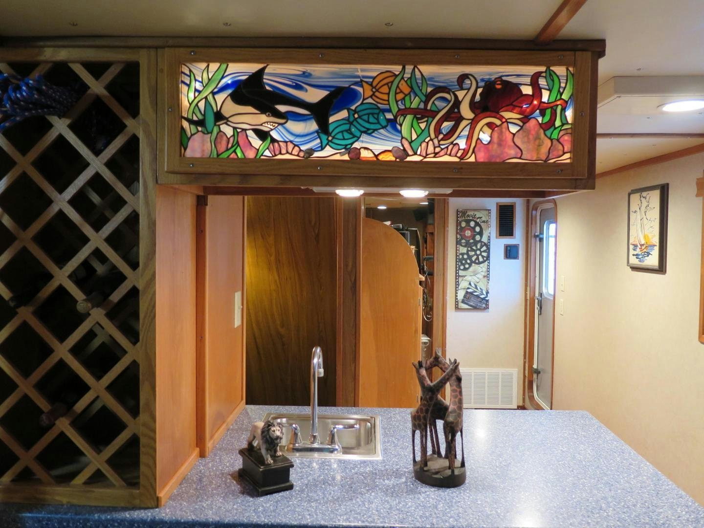 a statue of a cat in a room with a door and a wall with art on it aboard WANDERER Yacht for Sale