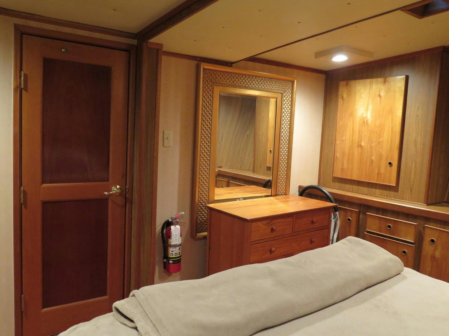 a bedroom with a bed and a wood door aboard WANDERER Yacht for Sale
